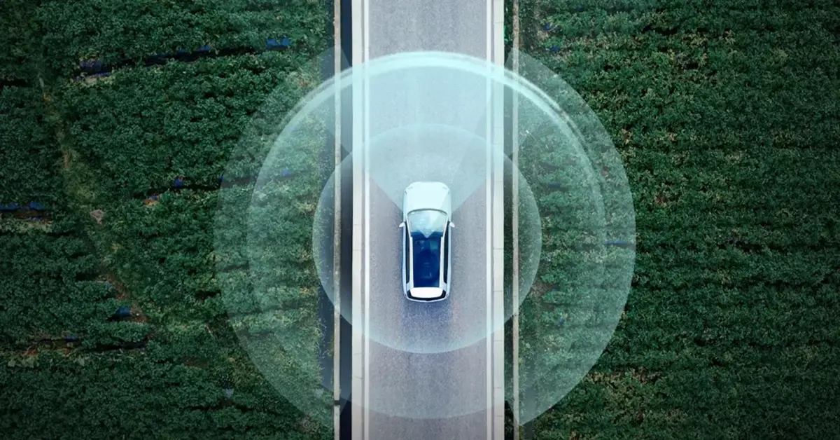 SUV electric GAC pe un drum printre câmpuri, văzut de sus, cu senzorii de asistență evidențiați grafic