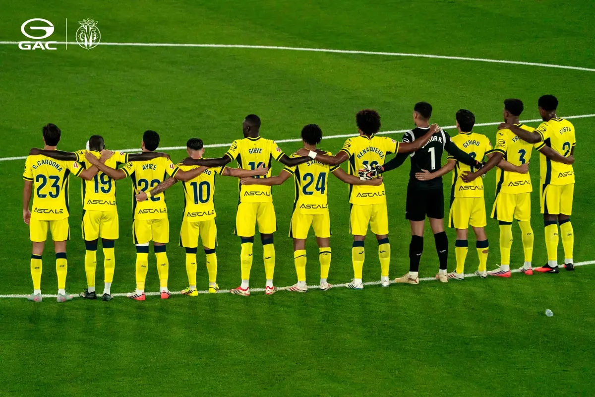 Jucătorii Villarreal CF aliniați pe teren, cu brațele pe umerii coechipierilor